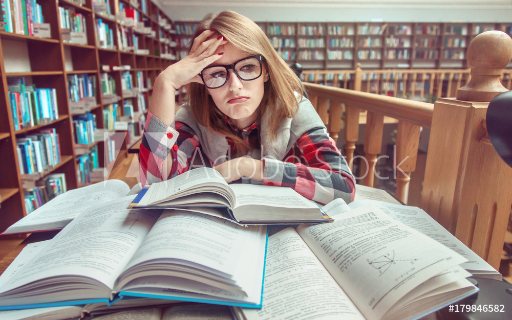 내년 학업 비중 커질 것…난도 높은 과목 유리 Confused and tired casual stylish student girl wears glasses studying hard with books in the library, education concept